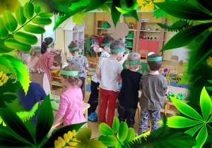 Dzieci ozdabiają sylwety dinozaurów.